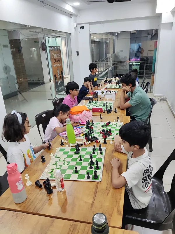 A full batch at their boards along the long table of the Surat Chess Club classroom near VIP Road, Vesu