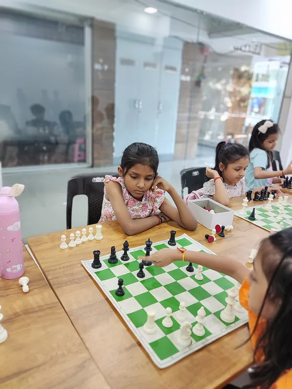 Two students side by side at a chessboard during a lesson at Surat Chess Club in Vesu