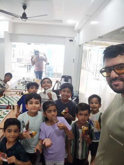 Students grinning for a group selfie with their coach after class