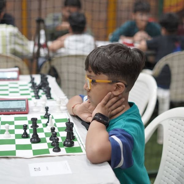 A young chess player in glasses thinking over his position at a Surat Chess Club tournament
